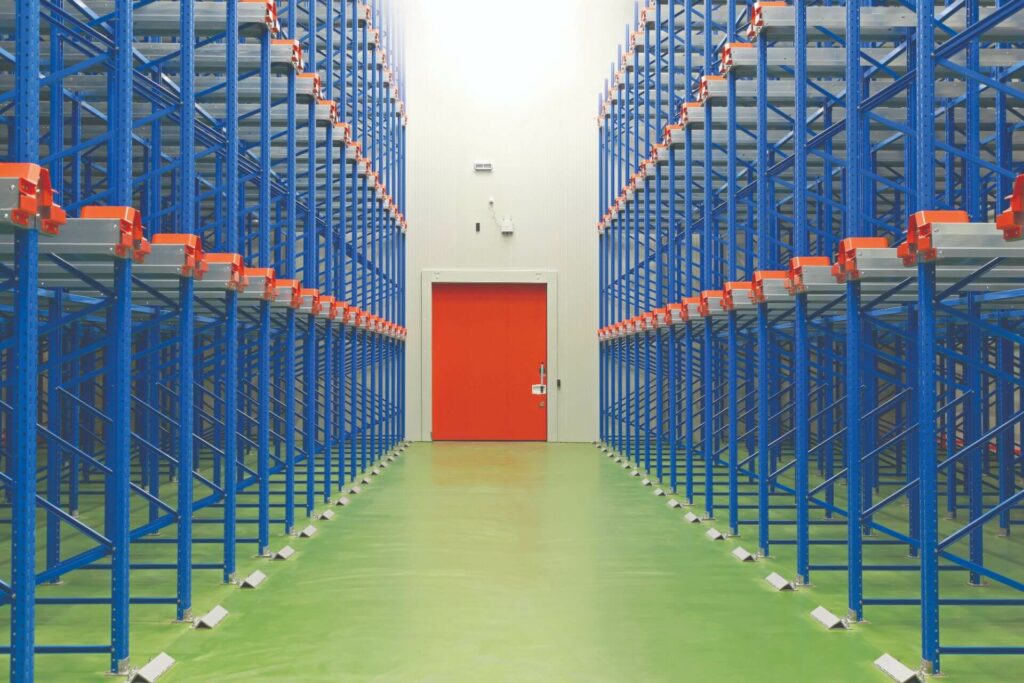 large warehouse with shelving units on each side of aisle