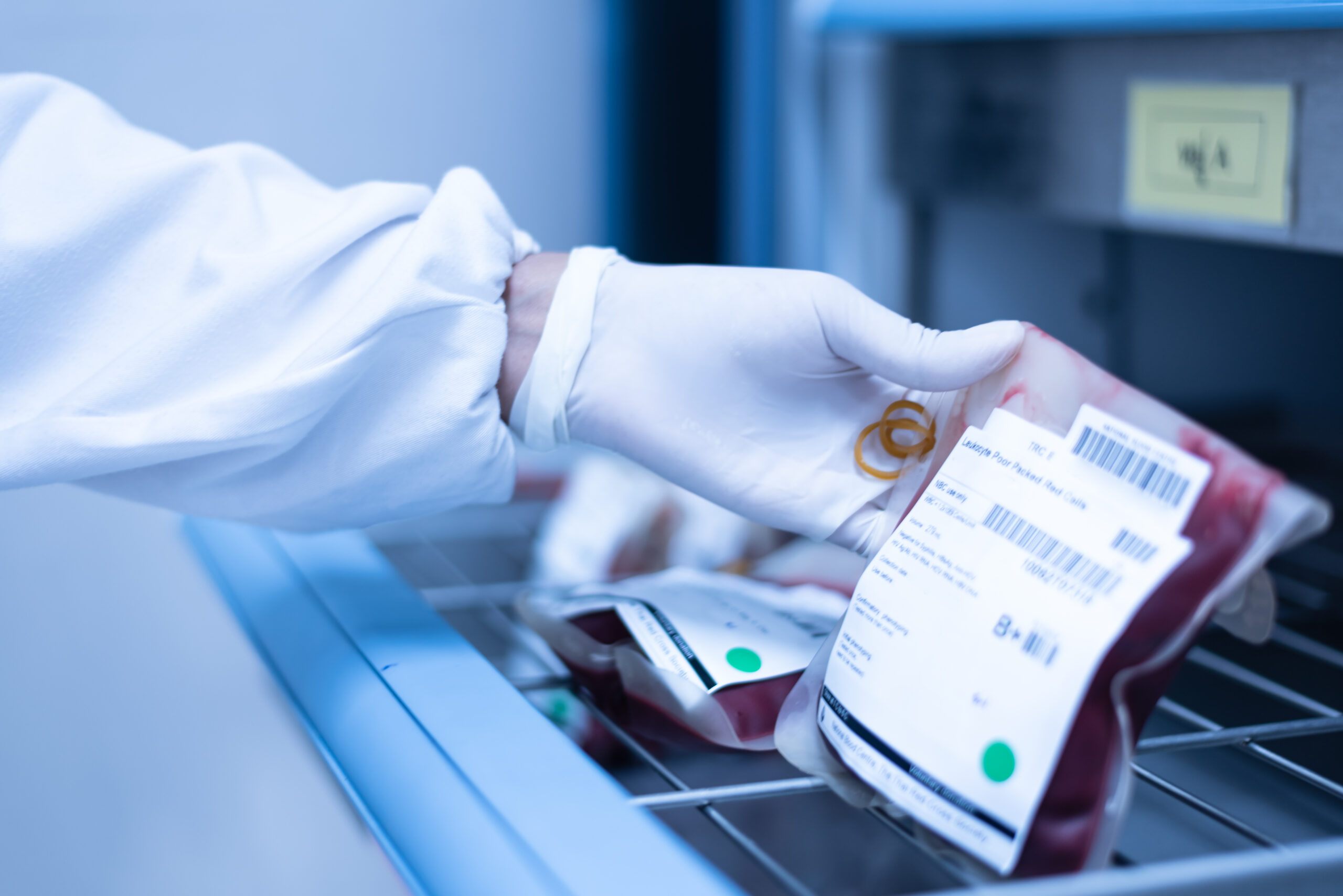 worker pulls bag of blood out of a container made of insulated panels for blood banks