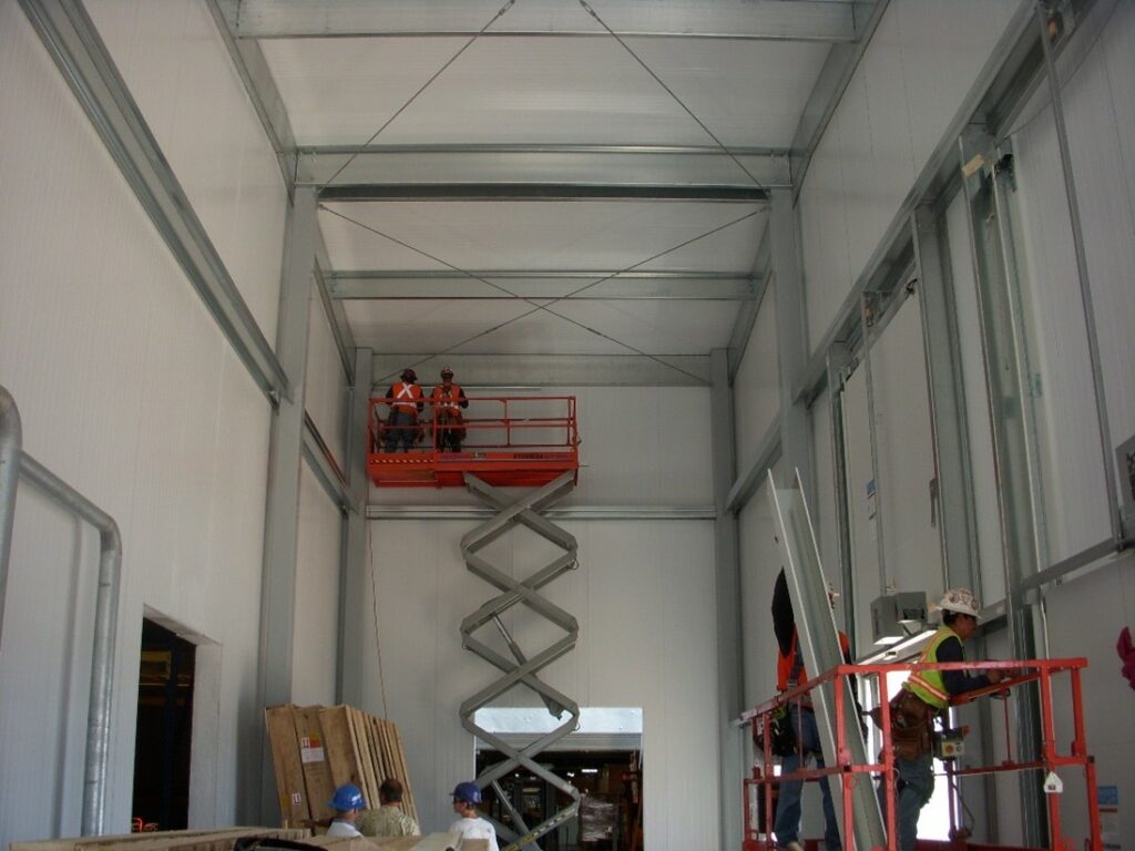 Large interior building under construction for healthcare facility utilizing insulated metal panels for walls.