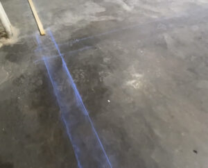 Blue chalk outline on concrete floor to create a square corner during panel installation