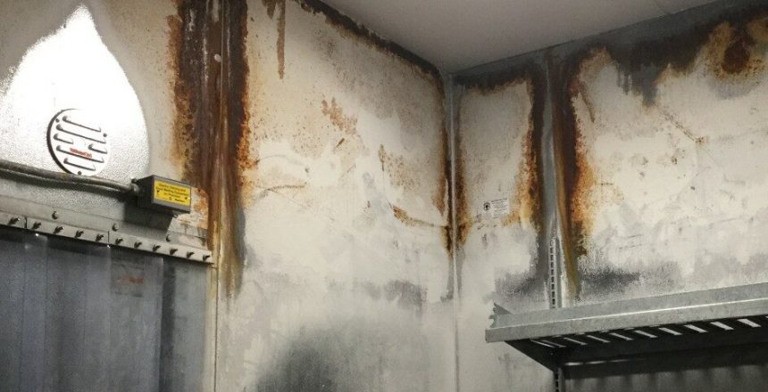 Interior of a rusted walk-in cooler in need of restore solutions, showcasing signs of corrosion and deterioration.