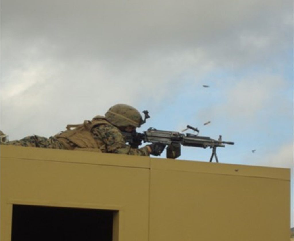 military soldier laying on top of a military shelter holding a sniper